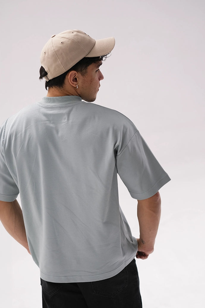 Beigefarbene Cap von Whisper of Inspiration in Rückenansicht an einer Person im sagegrünen T-Shirt vor hellem Studiohintergrund.